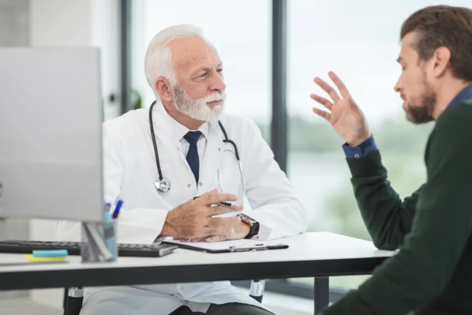Médico conversando con un paciente en el consultorio